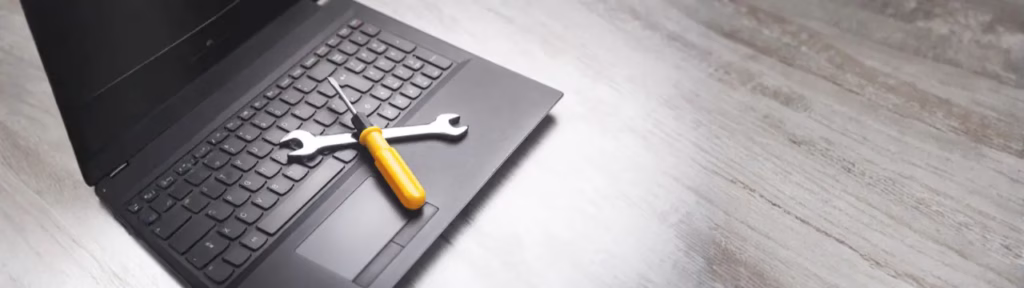 Laptop with wrench, screwdriver, and magnifying glass on top, representing website rescue and optimization tools for fixing underperforming sites.