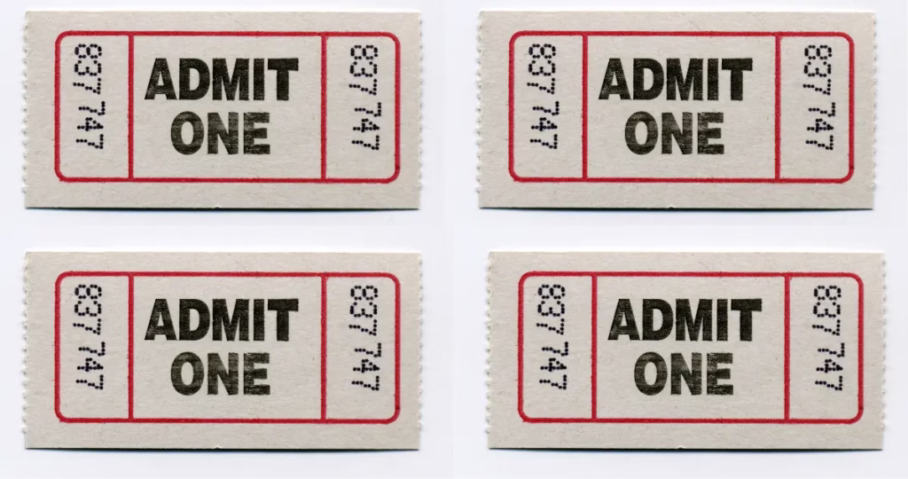 Four concert tickets spread out on a table, illustrating an accidental double purchase caused by a slow website and lack of button feedback.